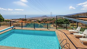 A swimming pool with a view of the ocean and distant hills. - 'Finca Verónica' with Sea View, Wi-Fi and Air Conditioning (Candelaria)
