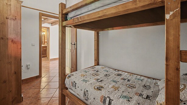 A bunk bed with a patterned mattress in a room with wooden beams and a tiled floor. - 'Finca Verónica' with Sea View, Wi-Fi and Air Conditioning (Candelaria)