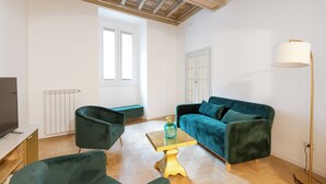A modern living room with a green sofa, a small table, and a floor lamp. - City Center- Modern and Bright apartment (Rome)