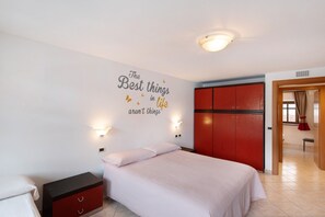 A bedroom with a bed, a wardrobe, a wall with a motivational quote, and a door leading to another room. - Apartment Gg 1 – Central Livigno, Includes Gold Discount Card for Local Services (Livigno)