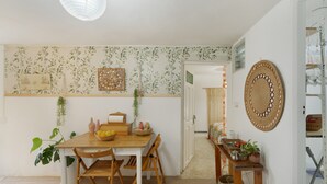 Comedor con una mesa de madera, sillas, una planta y un objeto decorativo en la pared.