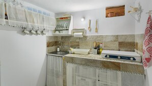 Cocina compacta con lavamanos, encimera y estufa.