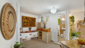 Una cocina compacta con comedor, un tapiz grande tejido a mano y un cuadro abstracto de colores.
