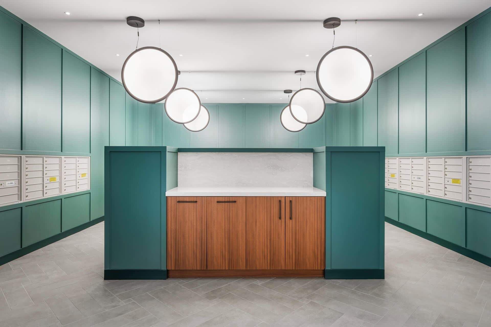 A modern kitchen with teal cabinetry, wooden cabinets, and a white countertop.