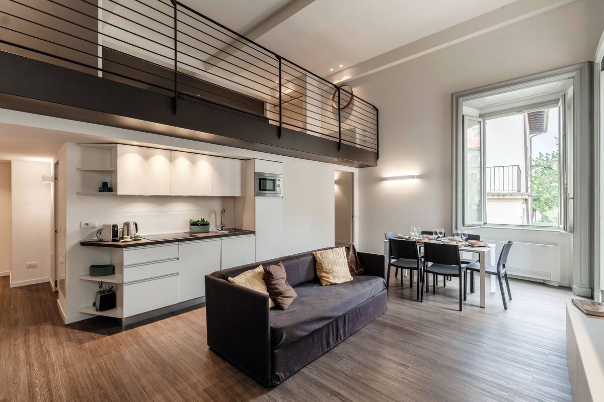 A modern interior with a sofa, dining table, and kitchen area.