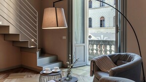 Ein modernes Interieur mit Treppe, einer Couch, einem Tisch mit Tassen und einer Lampe.