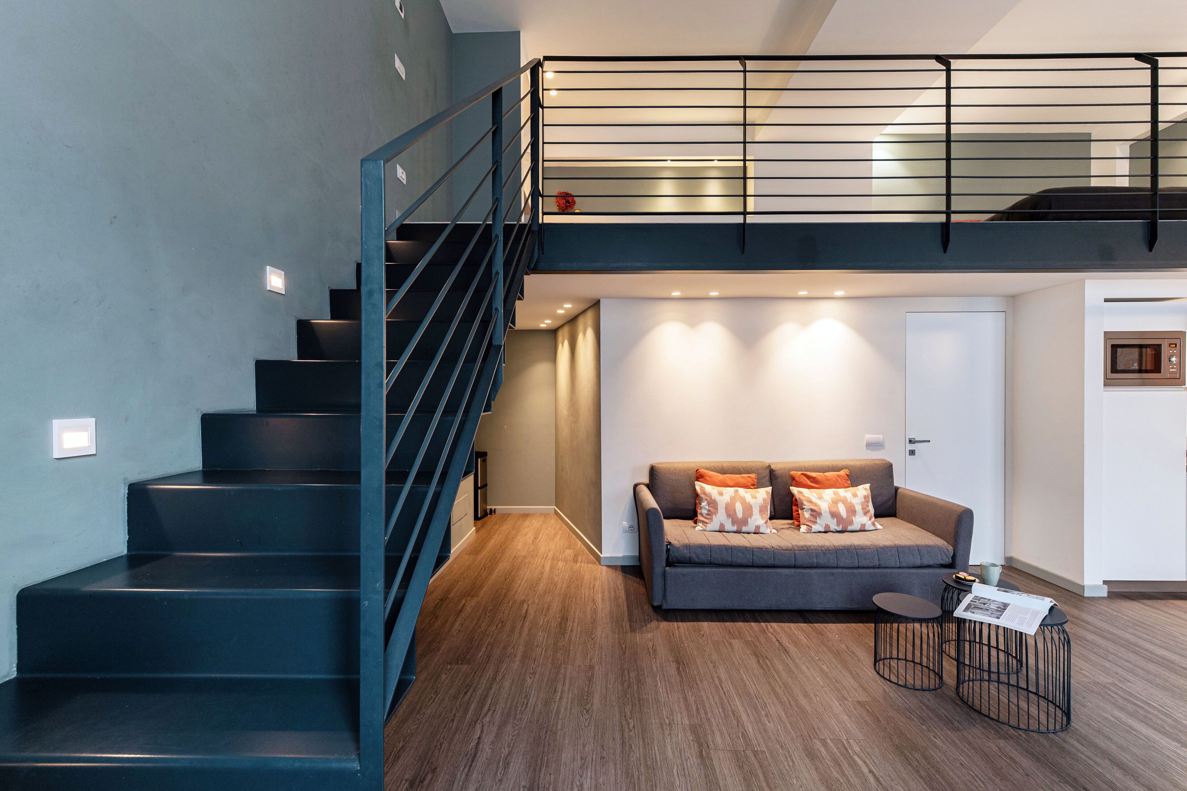 A modern interior with a staircase, a sofa, and a small table.