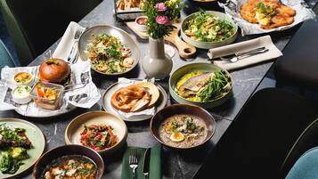 A dining table set with various dishes, including seafood, salads, and a bowl of soup.