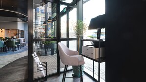 A modern interior with a seating area, a glass wall, and a view of the street. - Focus Hotel Premium Wrocław (Wroclaw)
