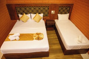 A double room with two beds, each with a wooden headboard, white linens, and a small nightstand.
