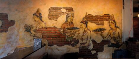 A mural with figures holding objects, a brick wall, and a QR code.