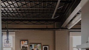 A modern living room with a sofa, coffee table, and artwork on the wall. - Modern Industrial Loft for Two (Benton Harbor)