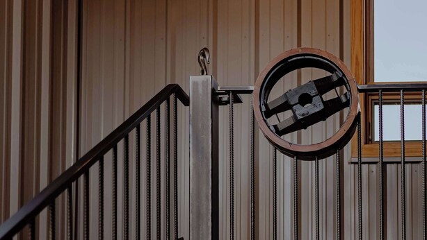 A wooden interior with a metal staircase, a circular window, and a visible exit sign. - Modern Industrial Loft for Two (Benton Harbor)