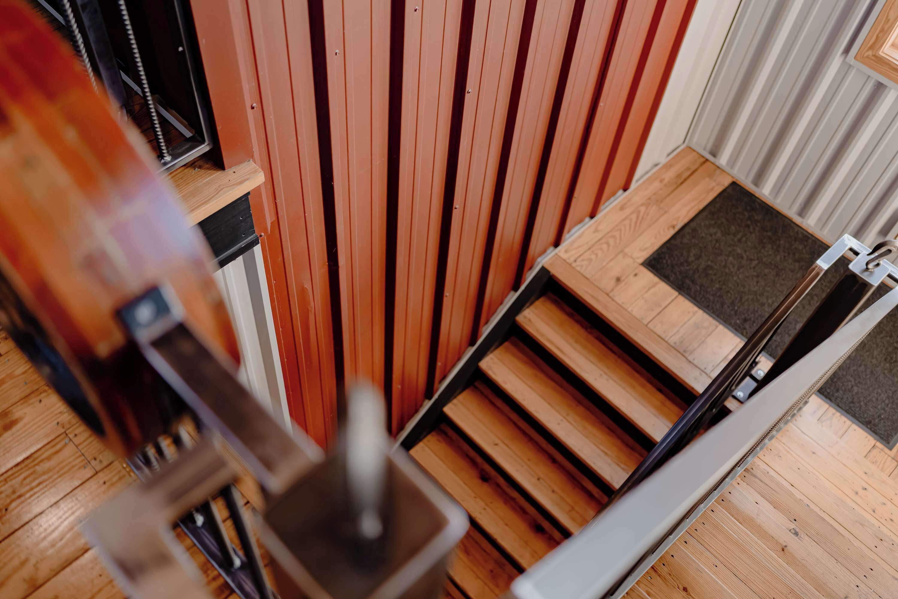 Un suelo de madera con una puerta corredera y estructura de metal.