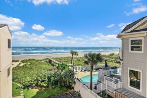 A beachfront property with a swimming pool, a deck, and a view of the ocean. - Beachfront Condo with Ocean Views & Pool Access (St. Augustine)