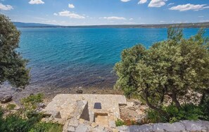 A coastal view with clear blue sea, rocky shoreline, and a stone structure in the foreground. - Villa Sadic Nearby Zadar - Crovillas (Posedarje)