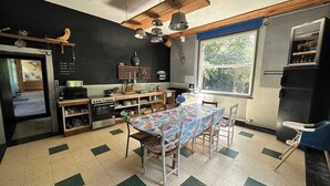 A kitchen with a dining table, chairs, a stove, and a refrigerator.