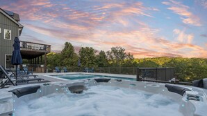A hot tub area with a pool, lounge chairs, and a deck overlooking a forested area. - Van Kirk Cove 6 BDR Stunner! (Branson West)