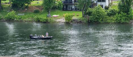 A house by a lake with a boat on the water.