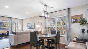 A modern dining area with a round table, chairs, and a chandelier. - Water's Edge & Golf Course View (Branson)