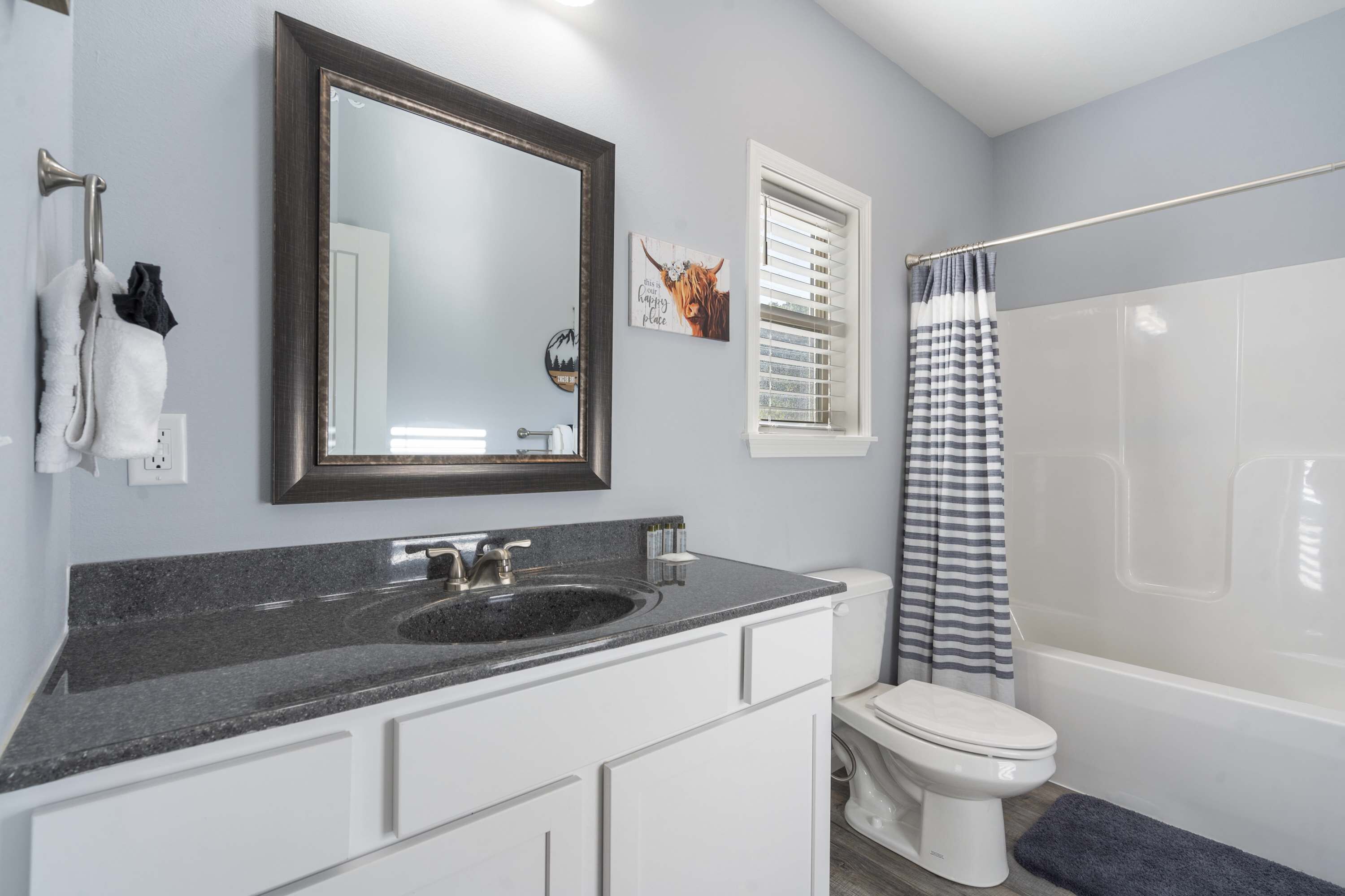 A bathroom with a sink, toilet, and bathtub.