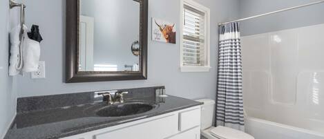 A bathroom with a sink, toilet, and bathtub.