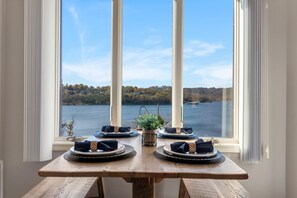 A dining table set for four with a view of a lake and hills in the background. - Lakescape at The Getaways (Kimberling City)
