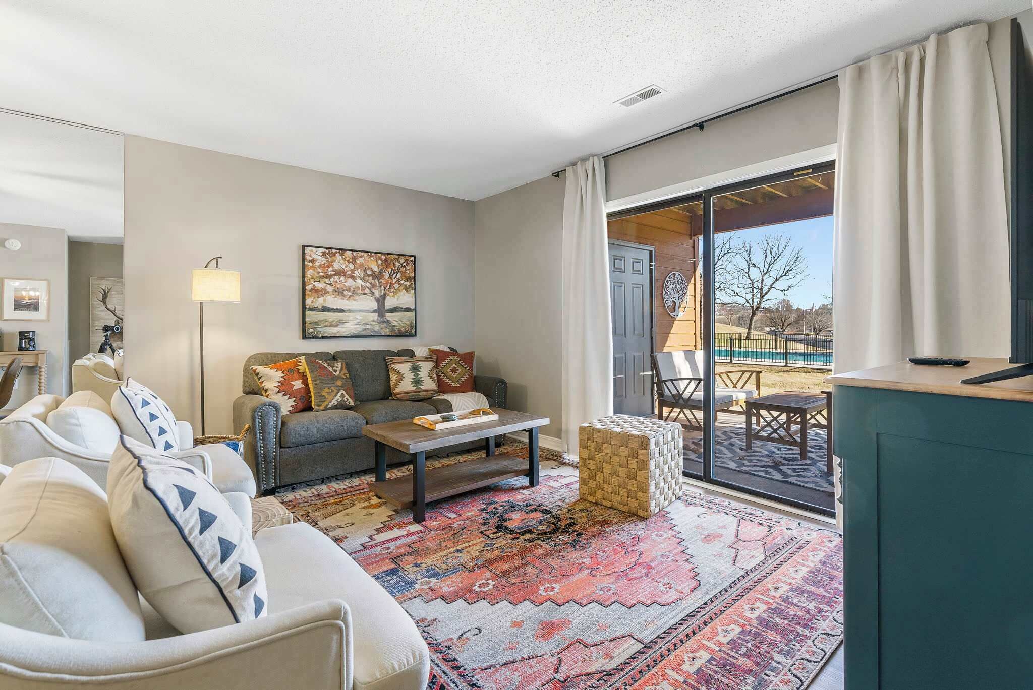 A modern living room with a sofa, coffee table, and a patterned rug.