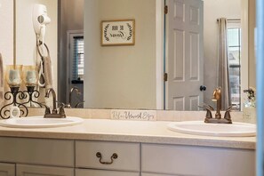 A bathroom with two sinks, a hairdryer, and a mirror. There is a sign on the wall that says 'Be your best self.' - Scenic Spot Vacation Property (Branson)