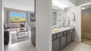 Une salle de bain moderne avec un double vasque, un meuble-lavabo et un grand miroir.