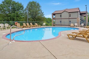 Relax by the pool surrounded by lush greenery and comfortable lounge chairs.