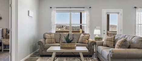 A living room with two sofas, a coffee table, and a view of the outdoors.