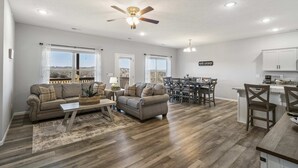 Ein geräumiges Wohnzimmer mit einer großen Couch, einem Couchtisch und einem Essbereich mit Tisch und Stühlen.