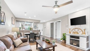 A modern living room with a leather sofa, a wooden coffee table, and a fireplace. - Lakeside Bliss Retreat 2 BDR (Branson)