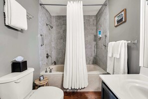 Ein modernes Badezimmer mit Badewanne, Toilette und Waschbecken.