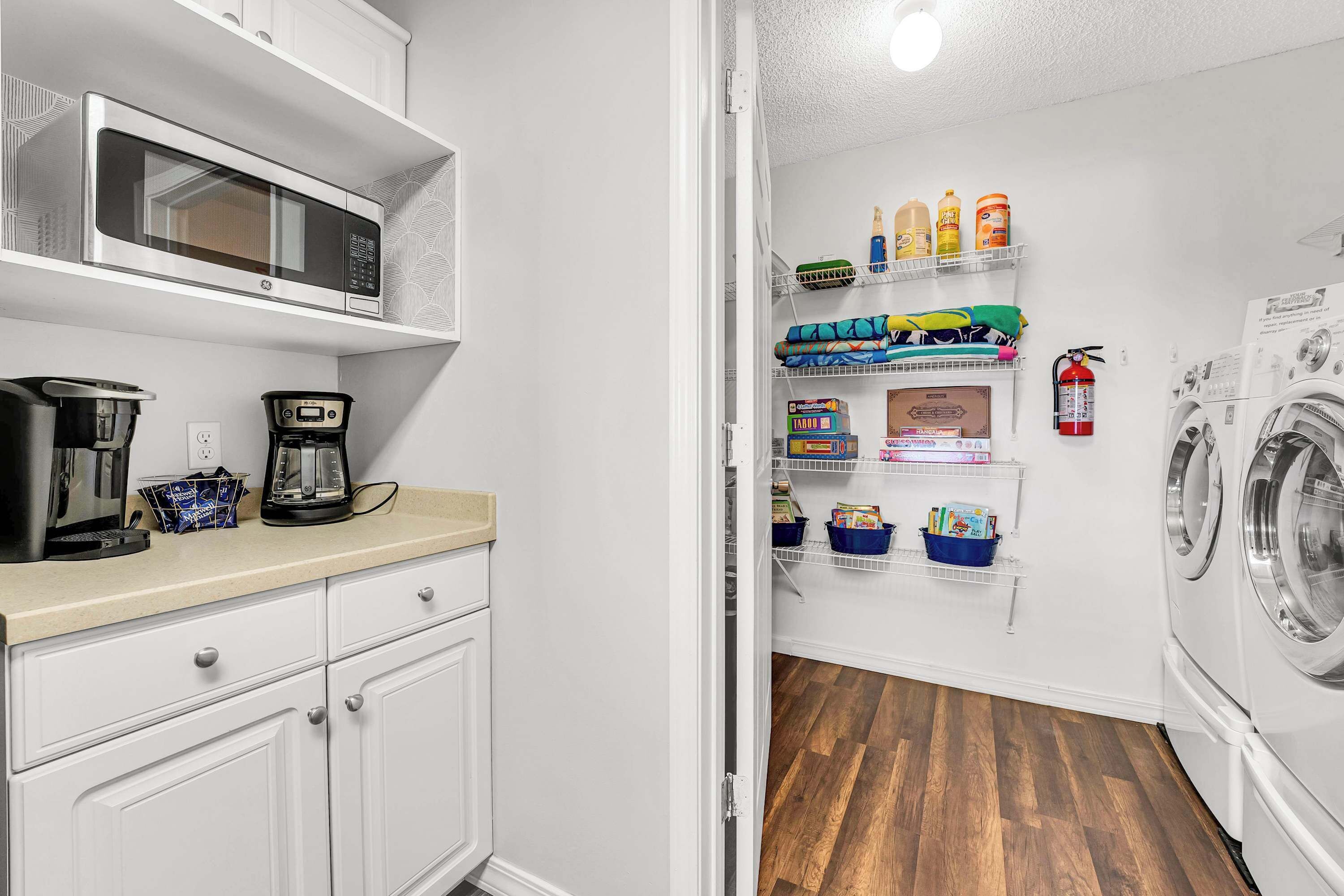 A compact kitchen with a microwave, coffee maker, and storage cabinets.