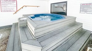 Een warmwaterbron met treden, omringd door witte muren.