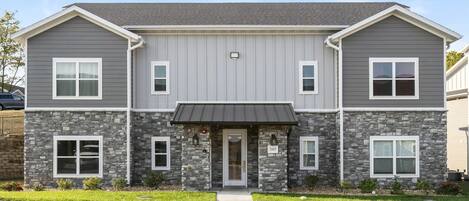 A two-story building with a stone facade and a flat roof.
