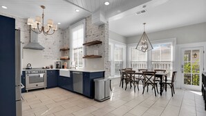 A modern kitchen with a built-in oven, a dishwasher, and a dining area with a table and chairs.