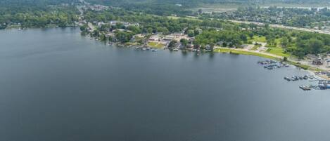 An aerial view of a lakeside town with a marina, residential areas, and a park.