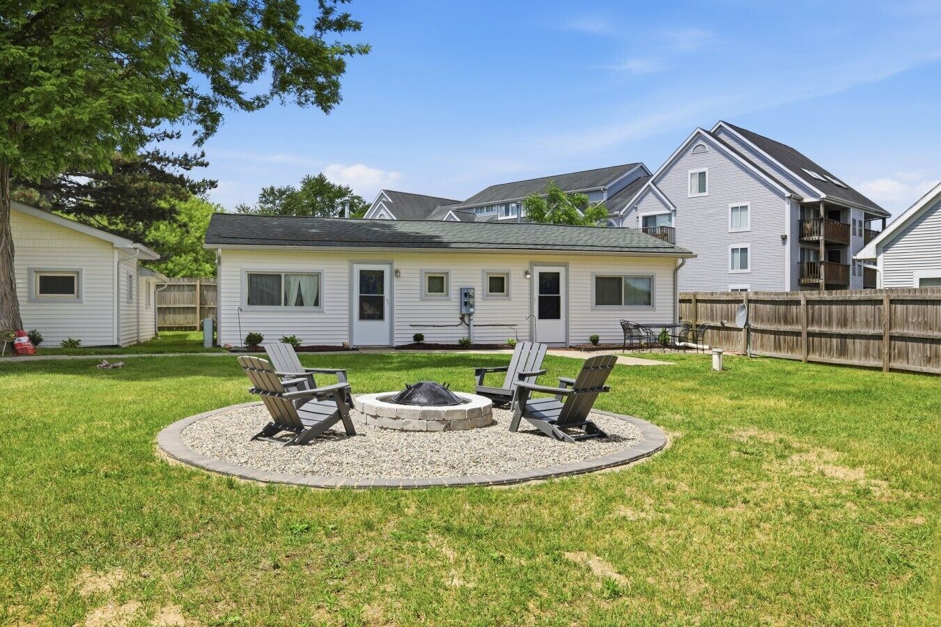 A residential property with a backyard featuring a fire pit and outdoor seating.