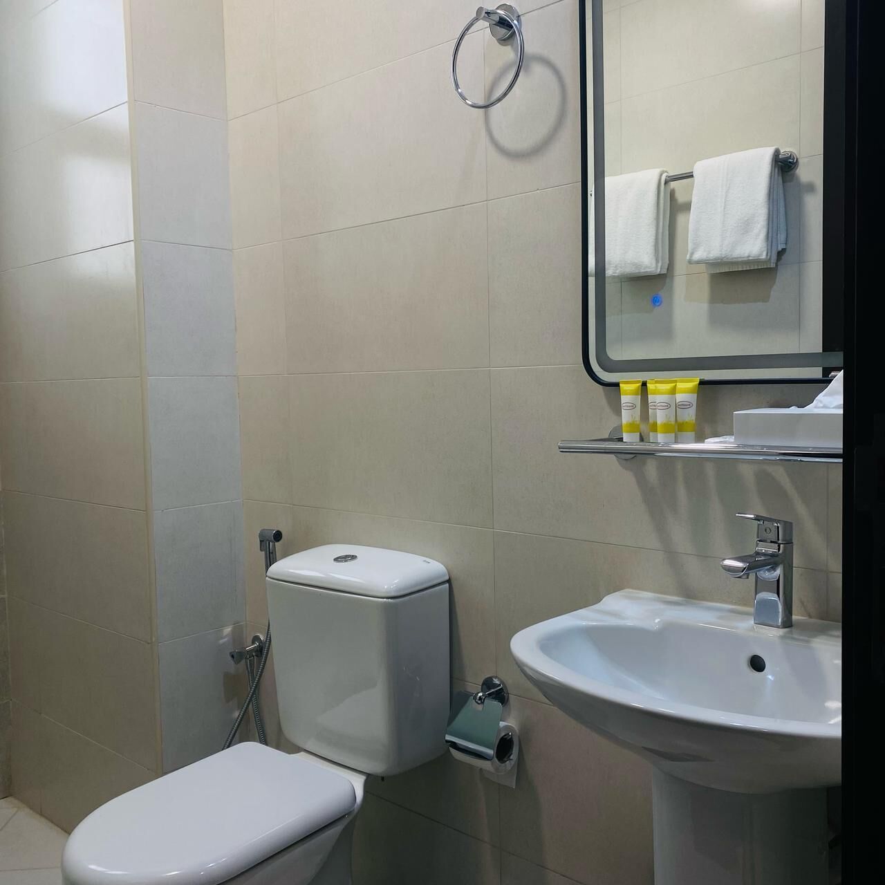 Un bagno con il water, lavandino e specchio.