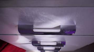 A close-up of a metallic handle on a piece of furniture, likely a cabinet or drawer.