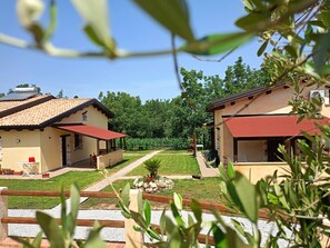 A residential area with two houses, each with a red roof and beige walls, surrounded by greenery and a clear sky. - RIACE VACATION HOMES TROPEA (Caria)