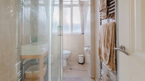 A bathroom with a glass shower enclosure, a toilet, and a towel rack. - Quaint 1BD Flat with Balcony in Maida Vale (Greater London)