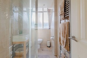 A bathroom with a glass shower enclosure, a toilet, and a towel rack. - Quaint 1BD Flat with Balcony in Maida Vale (Greater London)