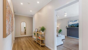 Um interior moderno com piso de madeira, um sofá branco, uma lareira e uma pintura grande na parede.