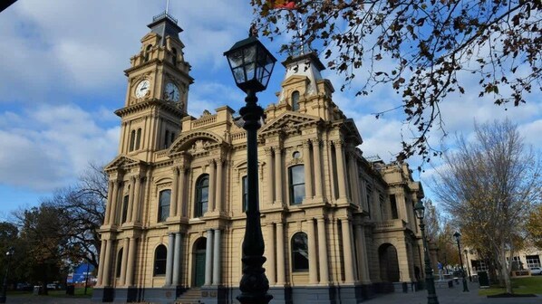 A large, historic building with two clock towers and a central dome.