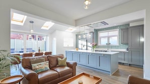 A modern kitchen with grey cabinets, a central island, and pendant lighting.