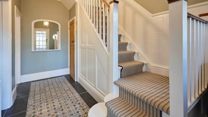 A staircase with a patterned carpet and a wooden handrail.